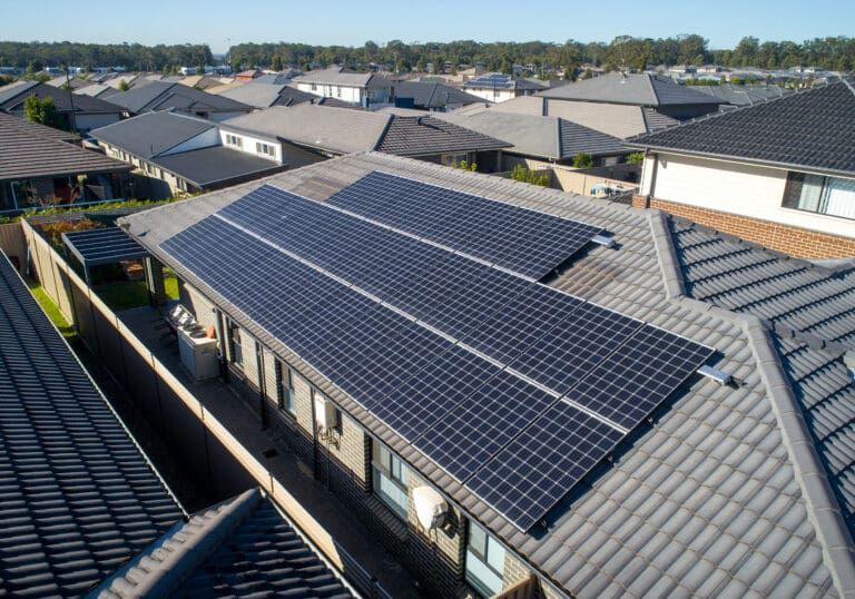 An aerial view of a house with solar panels on the roof.