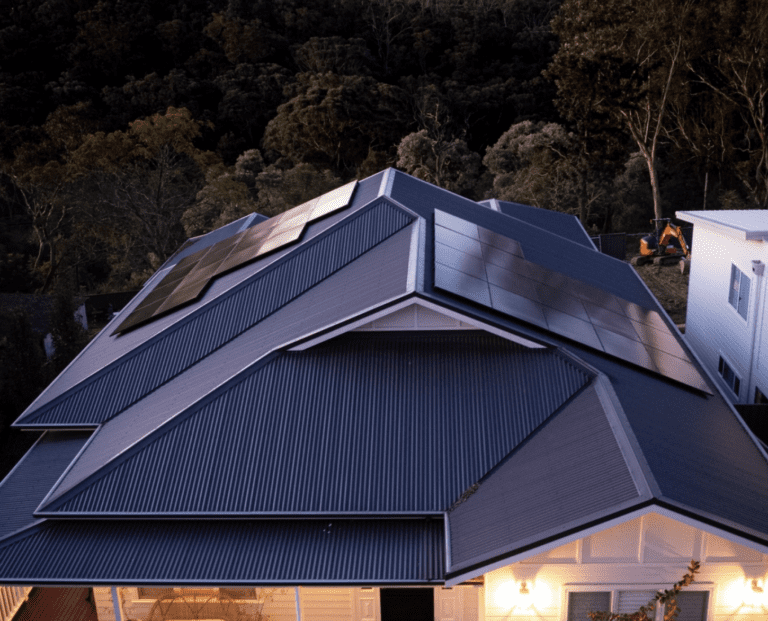 An aerial view of a house with solar panels on the roof.