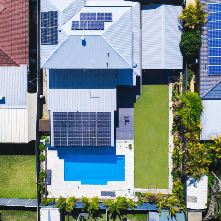 An aerial view of a house with solar panels on the roof.