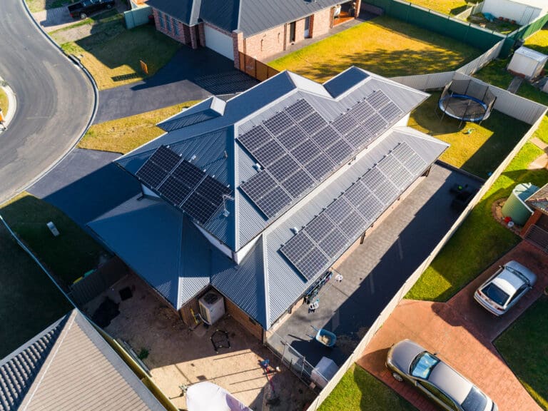 An aerial view of a house with solar panels on the roof.