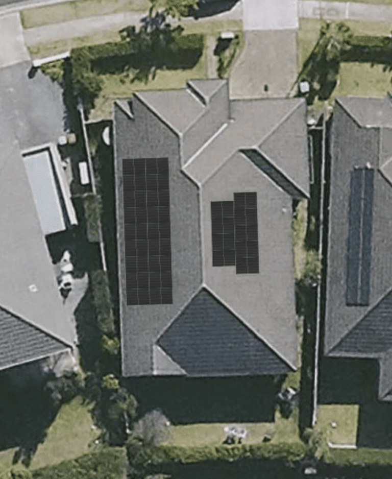 An aerial view of a house with solar panels on the roof.