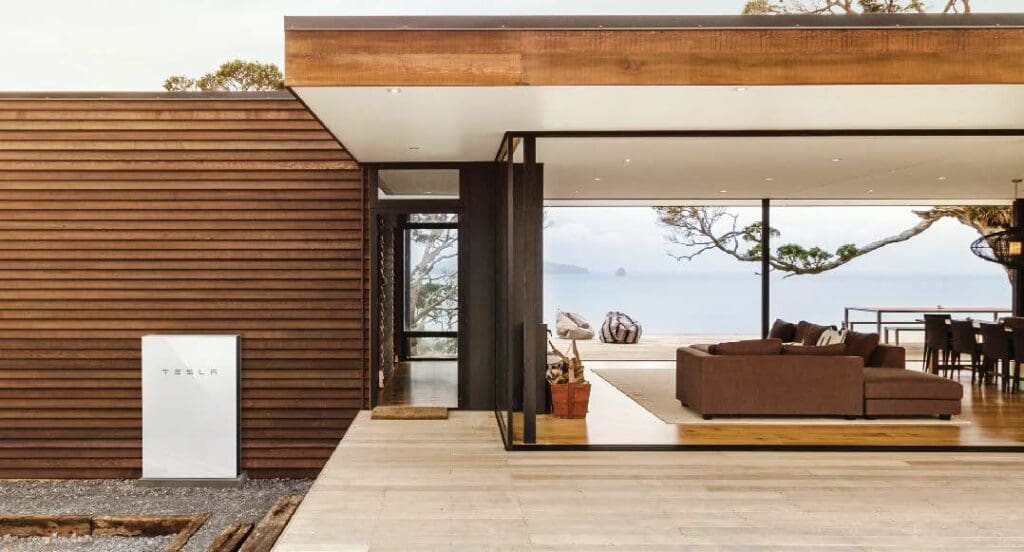 A modern house with a view of the ocean and a tesla powerwall.