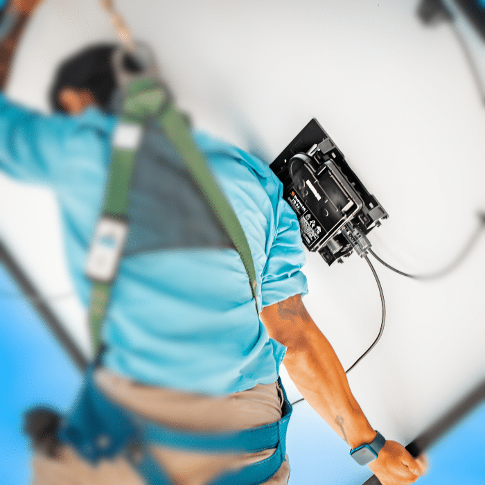Man carrying solar panel with microinverter.