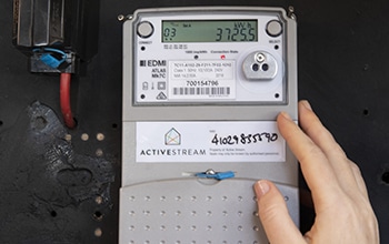 A hand touching a smart meter.